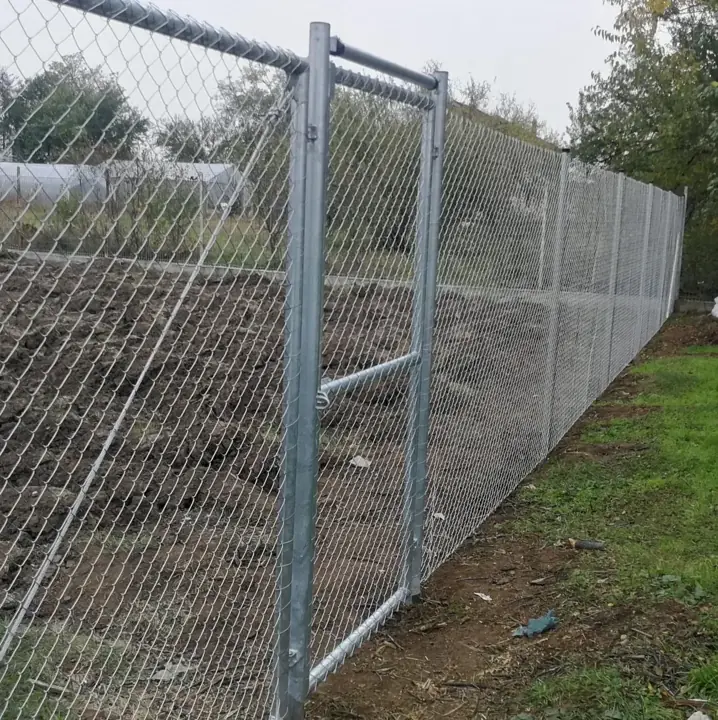Horganyzott drótfonatos kerítés acél oszlopokkal lejtős telekhatáron